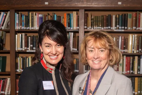 Two White woman, one in dark suit and with black hair, the other with auburn hair and a light suit