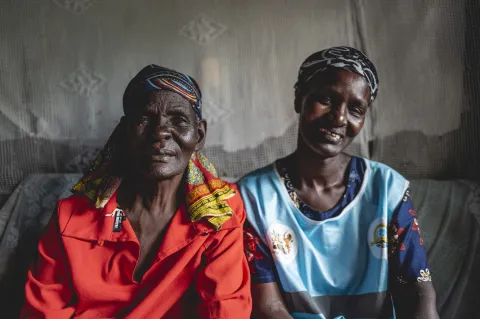 Two African women smiling into the camera, cut at chest.